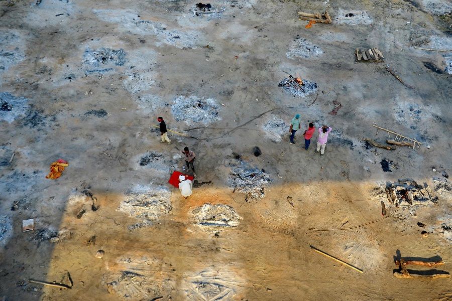 Relatives and family members can be seen as they collect the remains after performing the last rites of patients who died of the Covid-19 coronavirus at a site of a mass cremation in Allahabad, India on 27 April 2021. (Sanjay Kanojia/AFP)