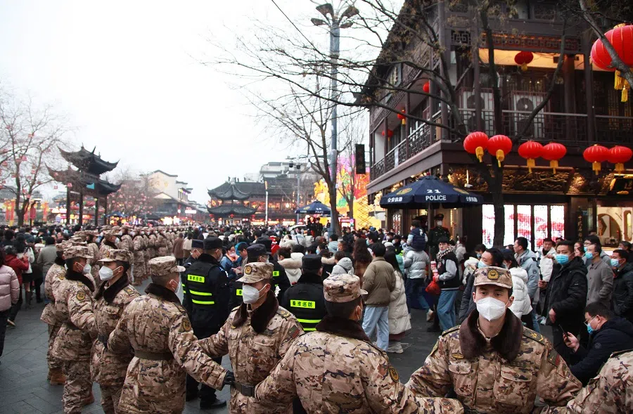 This photo taken on 5 February 2023 shows China's paramilitary police officers maintaining order as people visit Fuzimiao in Nanjing, Jiangsu province, China. (AFP)