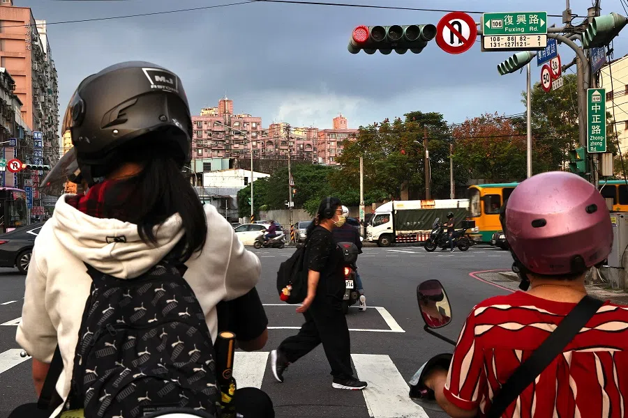 People cross the street during sunset rush hour in New Taipei City, Taiwan, 29 November 2022. (Ann Wang/Reuters)