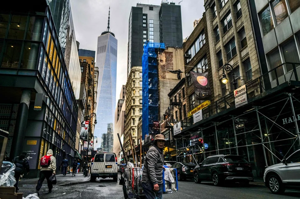 A woman pushes a cart of cleaning supplies in a street of the Manhattan borough of New York on 20 March 2024.  (Charly Triballeau/AFP)