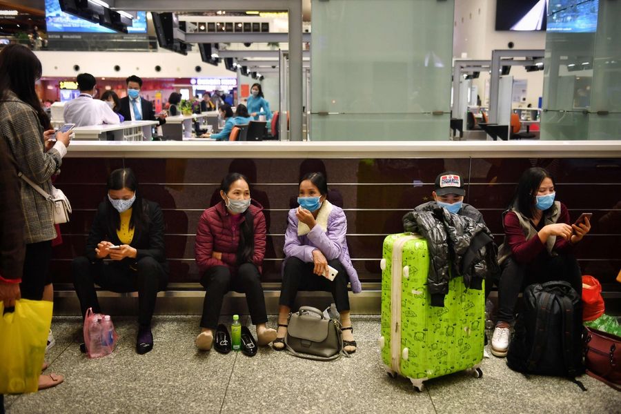 Passengers wear protective facemasks in the departure hall of Noi Bai International Airport in Hanoi on 6 February 2020. Health officials in Vietnam said on 5 February that all foreign passport holders, including those from China, Hong Kong and Macau, that have been to mainland China in the past 14 days will not be permitted to enter Vietnam. (Lillian Suwanrumpha/AFP)