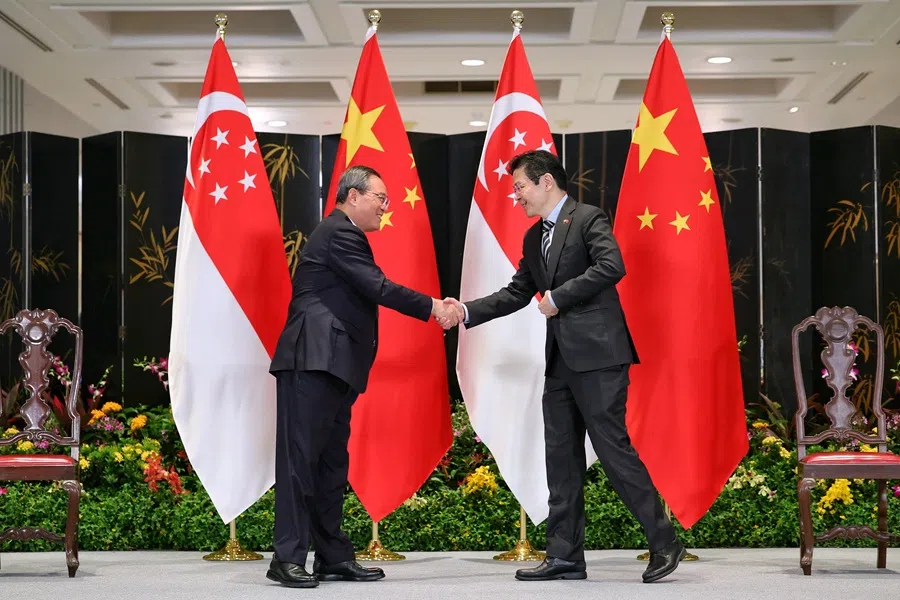 Chinese Premier Li Qiang and Singapore Prime Minister Lawrence Wong shake hands after witnessing the MOU exchange ceremony between representatives from the two countries in the Parliament House on 25 October 2025. (SPH Media)