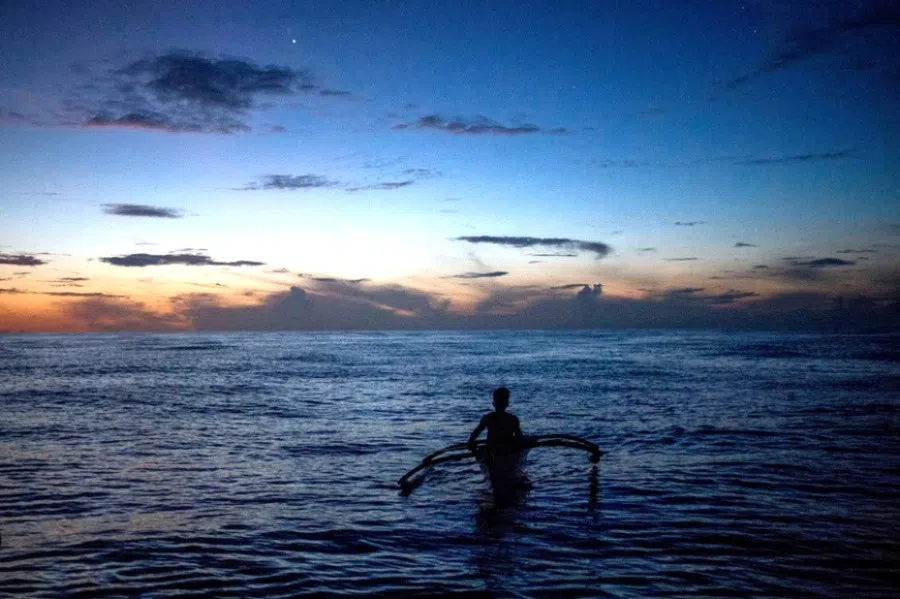 A Filipino fisheman rows a boat during a trip near the disputed Scarborough Shoal, in Masinloc, Zambales province, Philippines, 18 July 2022.