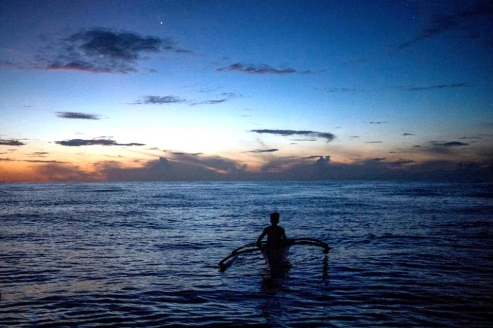 A Filipino fisheman rows a boat during a trip near the disputed Scarborough Shoal, in Masinloc, Zambales province, Philippines, 18 July 2022. (Lisa Marie David/Reuters)