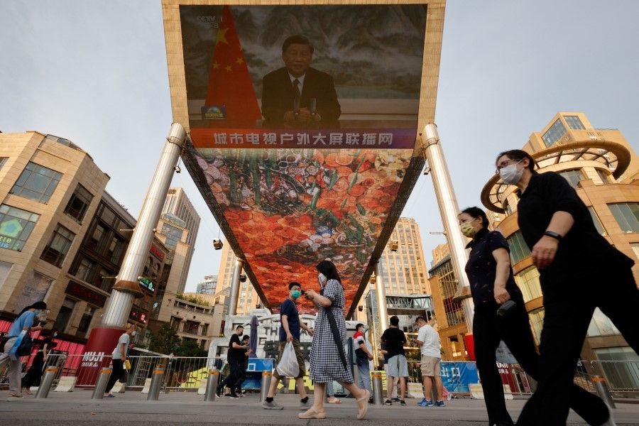 A screen shows a CCTV state media news broadcast of Chinese President Xi Jinping, addressing the BRICS Business Forum via video link, at a shopping center in Beijing, China, 23 June 2022. (Thomas Peter/Reuters)
