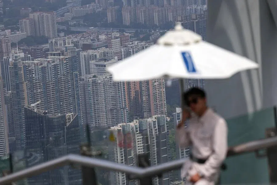 A staff member stands on a deck at Canton Tower overlooking residential buildings, in Guangzhou, Guangdong province, China, 17 March 2026. (Tingshu Wang/Reuters)