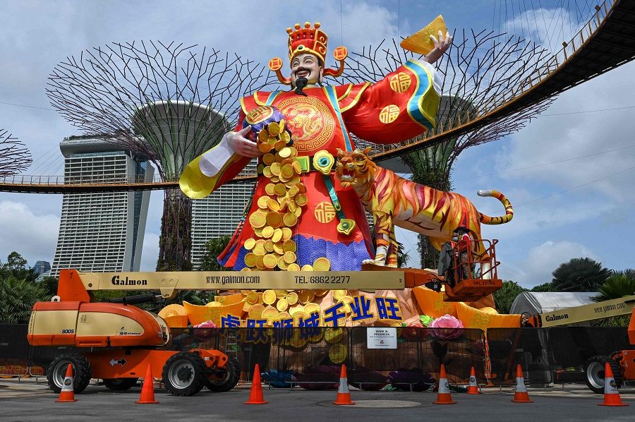 Workers give finishing touches on the "God of Fortune" lantern figurine for the upcoming Lunar New Year celebrations at the Gardens by the Bay Supertree Grove in Singapore on 18 January 2022. (Roslan Rahman/AFP)