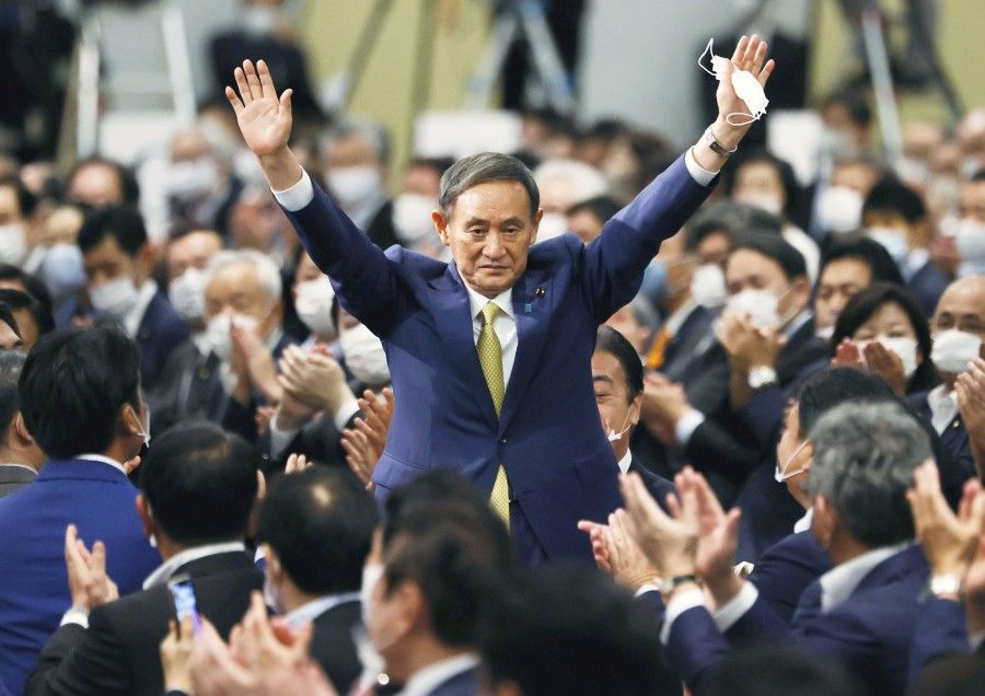 Yoshihide Suga gestures as he is elected as new head of the ruling party at the Liberal Democratic Party's (LDP) leadership election paving the way for him to replace Shinzo Abe, in Tokyo, 14 September 2020. (Kyodo via REUTERS)
