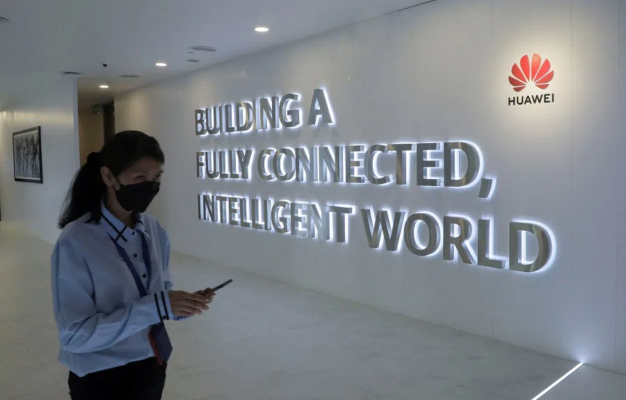 A Huawei staff uses her smartphone at the telecommunication company's Costumer Experience Centre in Kuala Lumpur, Malaysia, 11 January 2022. (Hussain Hasnoor/Reuters)