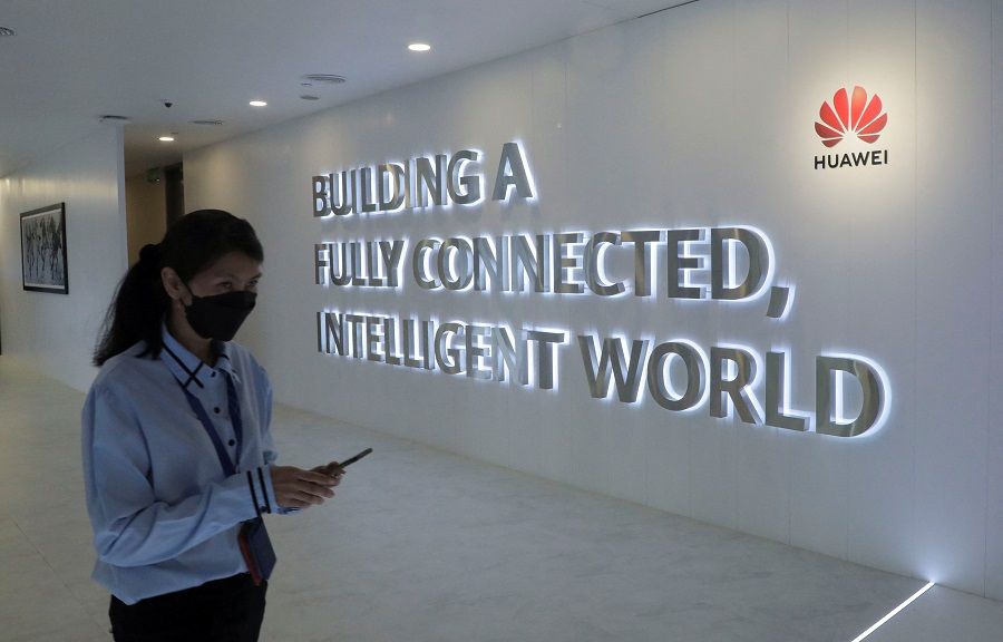 A Huawei staff uses her smartphone at the telecommunication company's Costumer Experience Centre in Kuala Lumpur, Malaysia, 11 January 2022. (Hussain Hasnoor/Reuters)