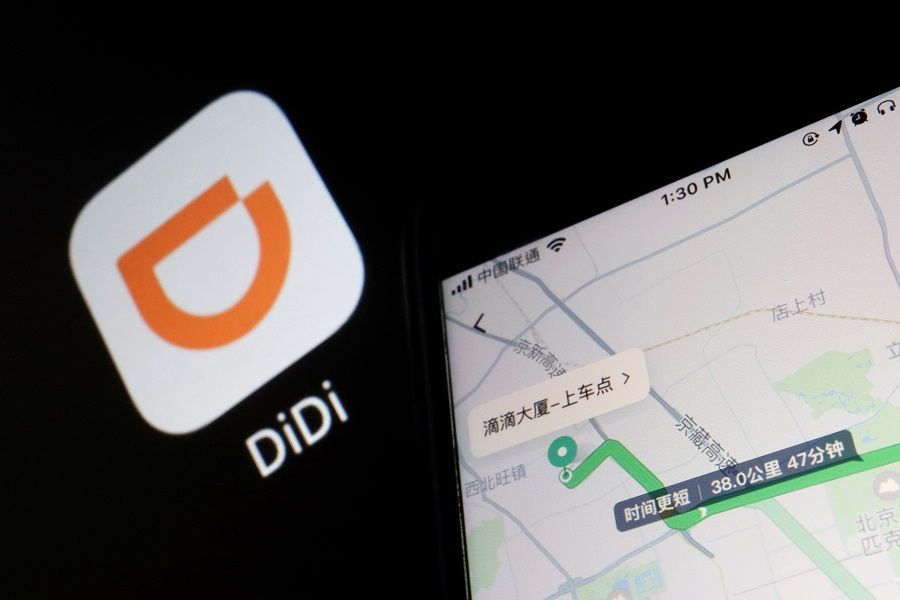 A navigation map on the app of Chinese ride-hailing giant Didi is seen on a mobile phone in front of the app logo displayed in this illustration picture taken 1 July 2021. (Florence Lo/Illustration/File Photo/Reuters)