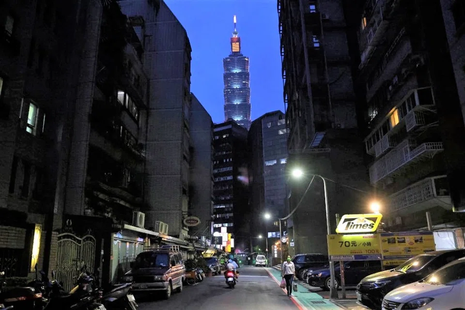 A woman wearing a protective face mask walks the street following a surge of coronavirus disease (COVID-19) infections in Taipei, Taiwan, 18 May 2021. (Ann Wang/Reuters)