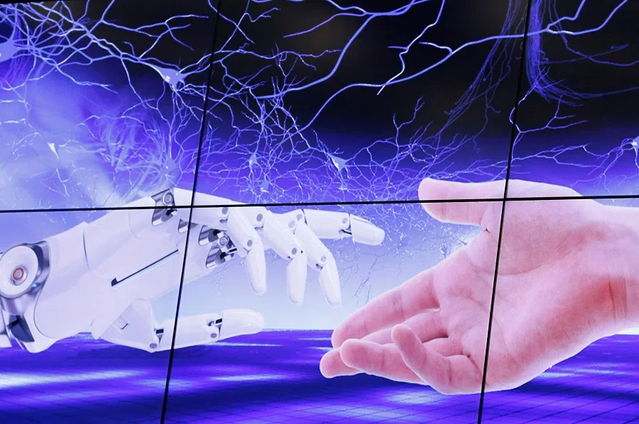 An illustration projected on a screen shows a robot hand and a human one moving towards each others during the "AI for Good" Global Summit at the International Telecommunication Union (ITU) in Geneva, Switzerland, 7 June 2017. (Denis Balibouse/File Photo/Reuters)