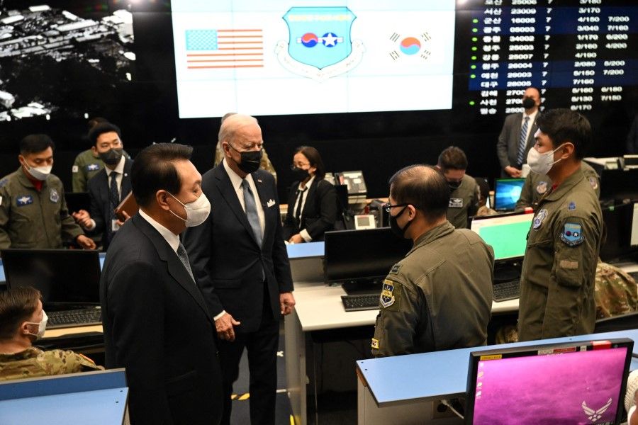 US President Joe Biden (centre), accompanied by South Korea's President Yoon Suk-yeol (left), tours the Air Operations Center's Combat Operations Floor at Osan Air Base in Pyeongtaek on 22 May 2022. (Saul Loeb/AFP)