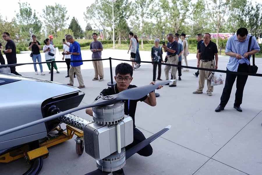 An engineer inspects the propellers of the electric flying car XPeng Voyager X2 by XPeng Aeroht, before a demonstration flight in Beijing, China, on 18 June 2024. (Tingshu Wang/Reuters)