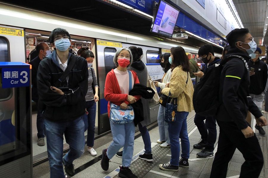People wearing masks to prevent the spread of Covid-19 get off a subway at the subway station during morning rush hour, in Taipei, Taiwan, 30 November 2021. (I-Hwa Cheng/Reuters)