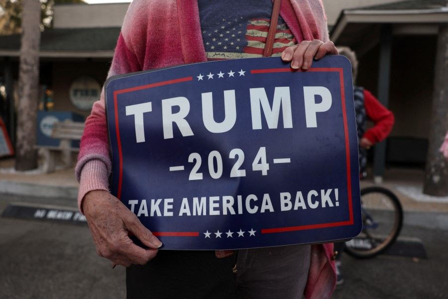 A supporter of Republican presidential candidate and former US President Donald Trump holds a sign outside Forrest Fire BBQ restaurant ahead of a campaign event of Republican presidential candidate and former US ambassador to the United Nations Nikki Haley in Hilton Head, South Carolina, US, on 1 February 2024. (Shannon Stapleton/Reuters)