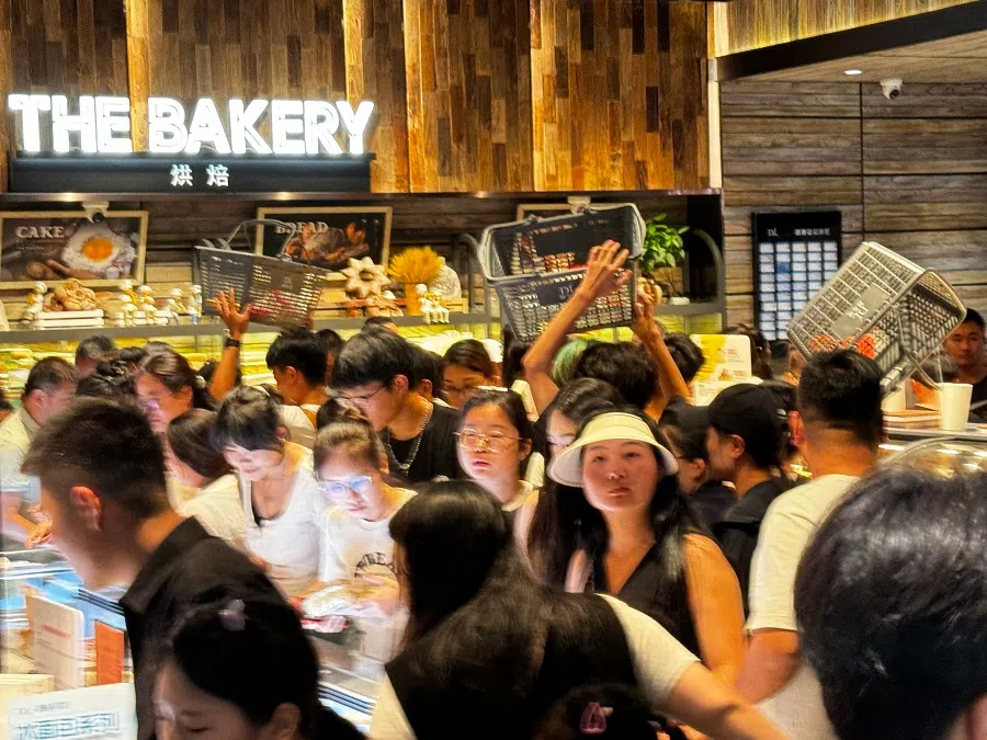 Business is booming at the Pang Dong Lai supermarket, with customers raising their shopping baskets above their heads just to move around.