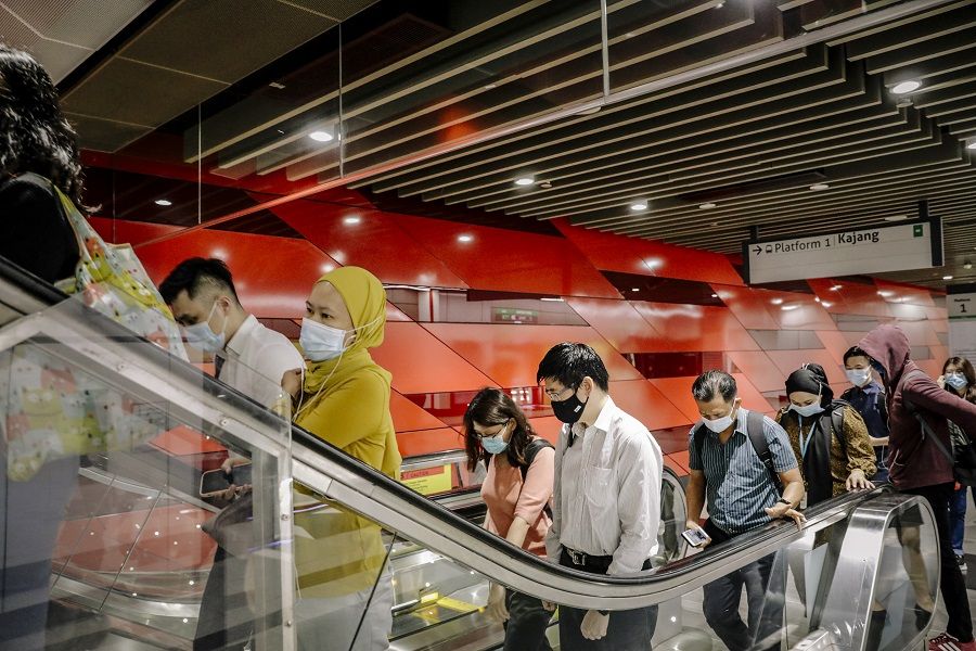 Commuters ride an escalator in Kuala Lumpur, Malaysia, on 5 April 2021. (Ian Teh/Bloomberg)