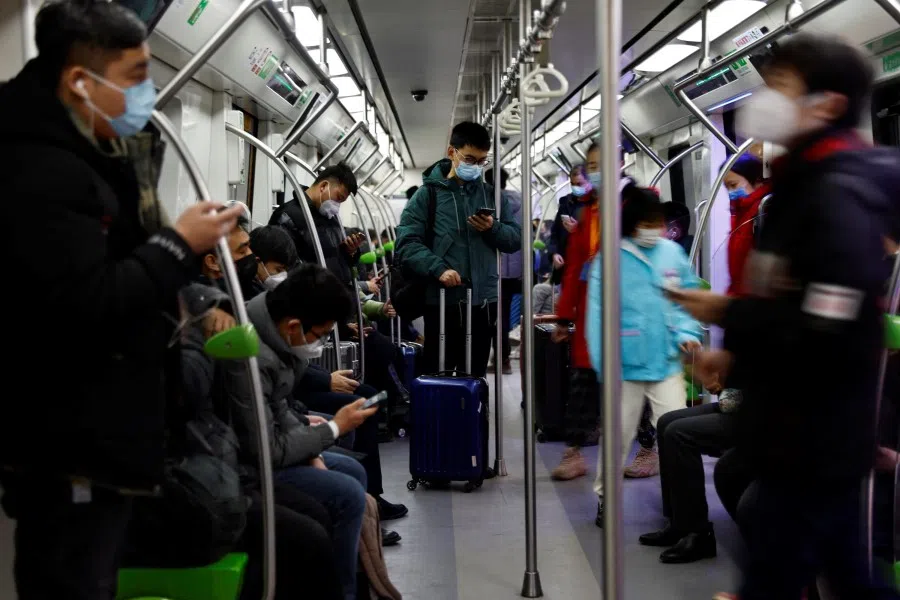 Passengers ride on a subway with suitcases on a subway in Beijing, China, 2 February 2023. (Tingshu Wang/Reuters)