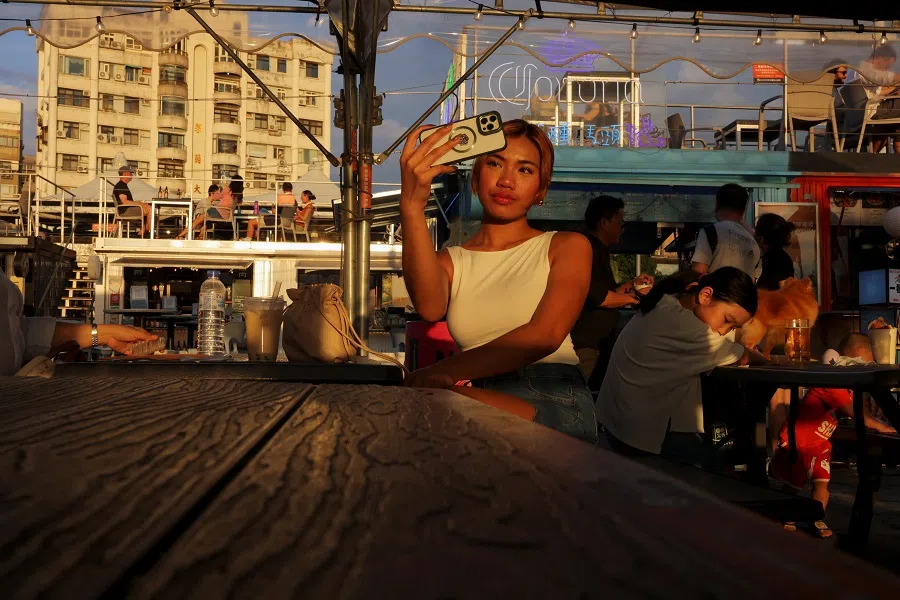 Customers sit at a riverside bar during sunset in Taipei, Taiwan, on 2 July 2024. (Annabelle Chih/Reuters)