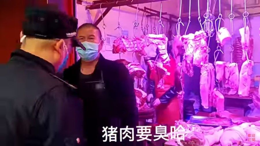 A screen grab from a video featuring a butcher arguing with a policeman about keeping his shop open, as he says that his stock of pork is going bad. (Internet)