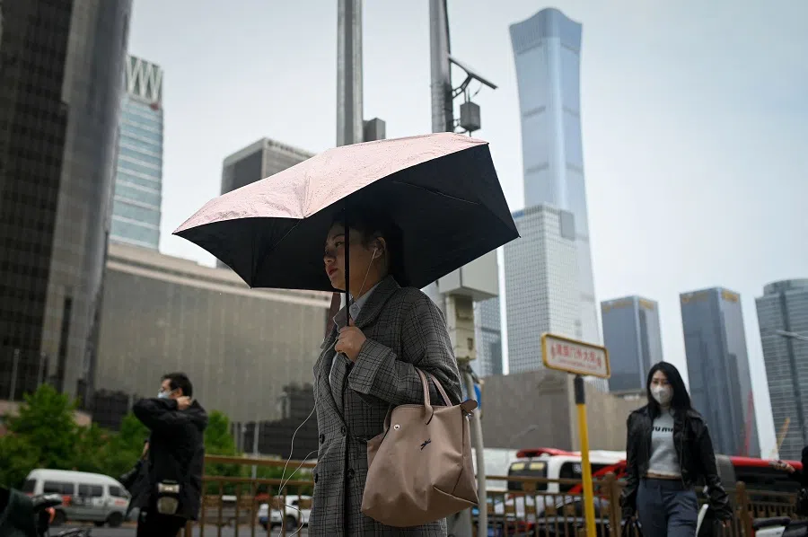 People walk on a street in Beijing, China, on 5 May 2023. (Wang Zhao/AFP)