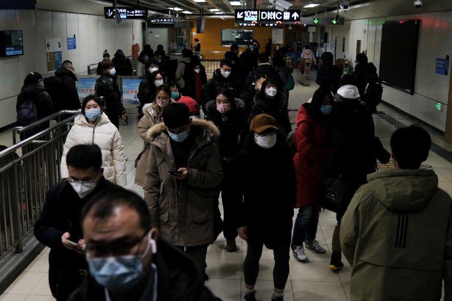 People walk at a subway station during evening rush hour in Beijing, China, 16 January 2023. (Tingshu Wang/Reuters)