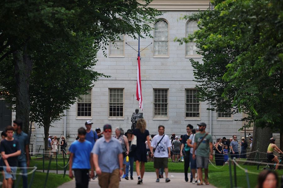 Visitors walk through the Yard near the John Harvard Statue at Harvard University in Cambridge, Massachusetts, US, 6 July 2023. (Brian Snyder/Reuters)