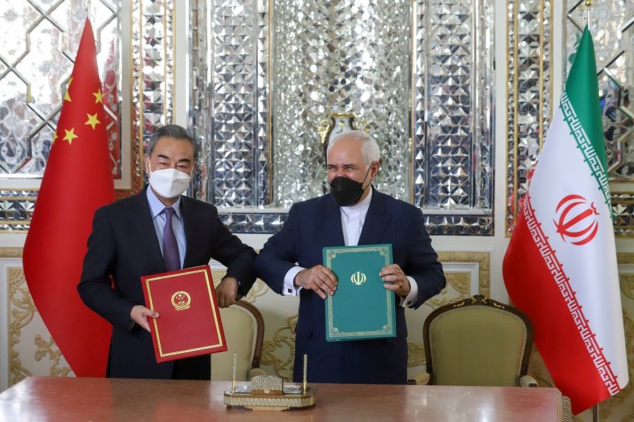 Iran's Foreign Minister Mohammad Javad Zarif and China's Foreign Minister Wang Yi bump elbows during the signing ceremony of a 25-year cooperation agreement, in Tehran, Iran, 27 March 2021. (Majid Asgaripour/West Asia News Agency via Reuters)