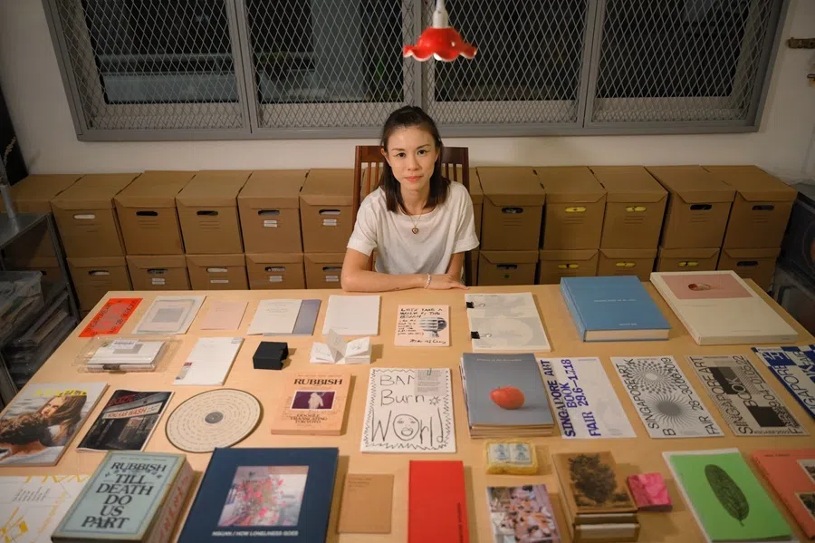 Singapore Art Book Fair founder Renee Ting with some zines and books from the fair over the years, 7 October 2024.