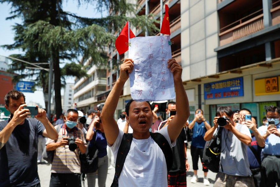 A man shouts slogans in front of the former US Consulate-General in Chengdu, 27 July 2020. (Thomas Peter/REUTERS)