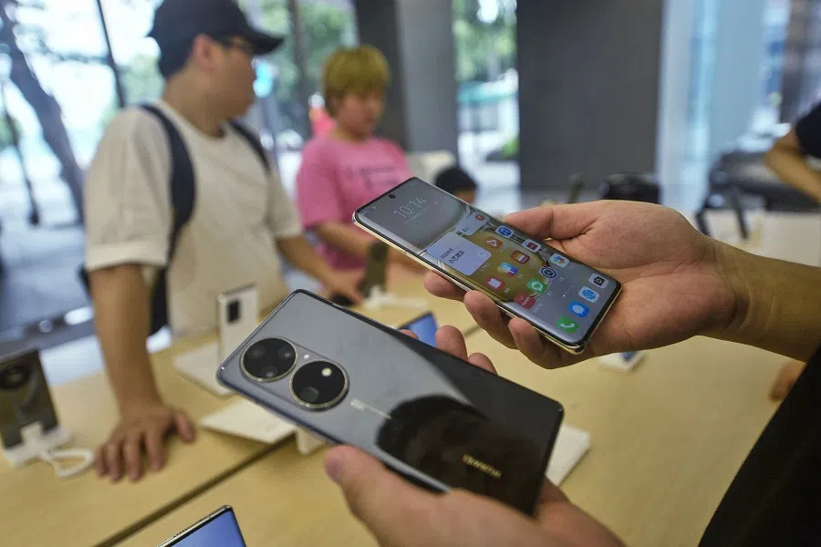 A customer looks at a newly launched Huawei P50 mobile phone at a Huawei store in Hangzhou, Zhejiang province, China, on 30 July 2021. (STR/AFP)