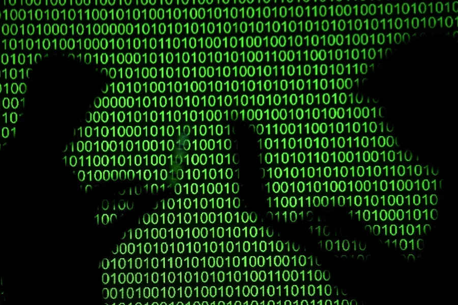 Silhouettes of laptop users are seen next to a screen projection of binary code are seen in this picture illustration taken 28 March 2018. (Dado Ruvic/Illustration/File Photo/Reuters)