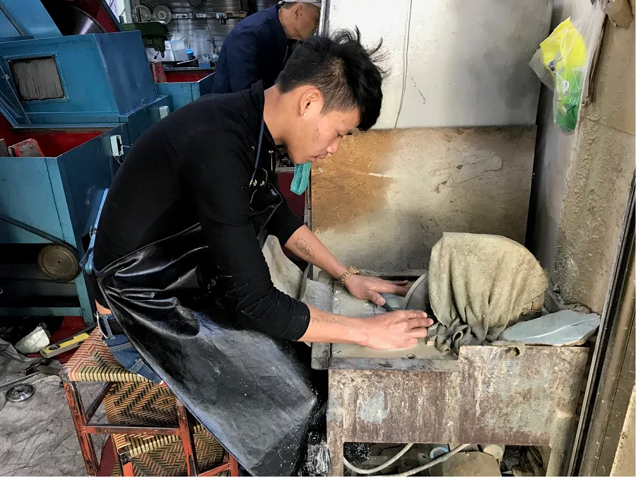 A worker polishing jade stones in Ruili, Yunnan province, on 4 January 2019. (Chen Xiangming)
