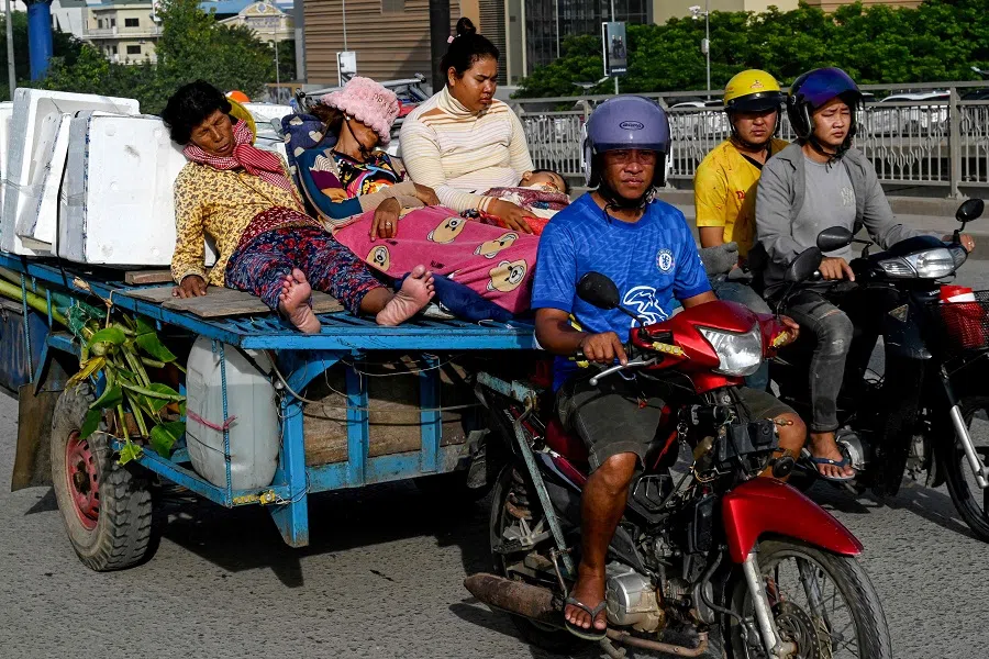 Women rest on the back of a motor-cart driving on a street in Phnom Penh on 10 September 2024. (Tang Chhin Sothy/AFP)