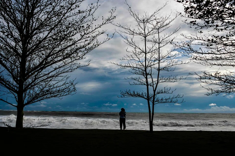 A woman looks out to the Indian Ocean at Meulaboh beach in Aceh on 12 July 2020. (Chaideer Mahyuddin/AFP)