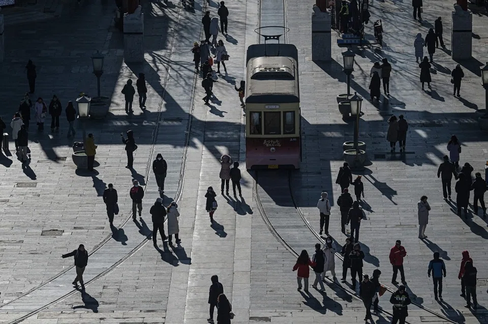 People walk on Qianmen street as seen from Zhengyangmen Gate, the ancient watchtower south of Tiananmen Square, in Beijing on 9 January 2025. (Jade Gao/AFP)