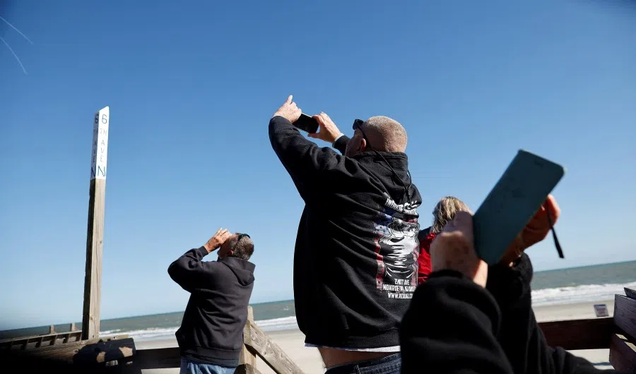 People photograph a suspected Chinese spy balloon as it floats off the coast in Surfside Beach, South Carolina, US, 4 February 2023. (Randall Hill/Reuters)