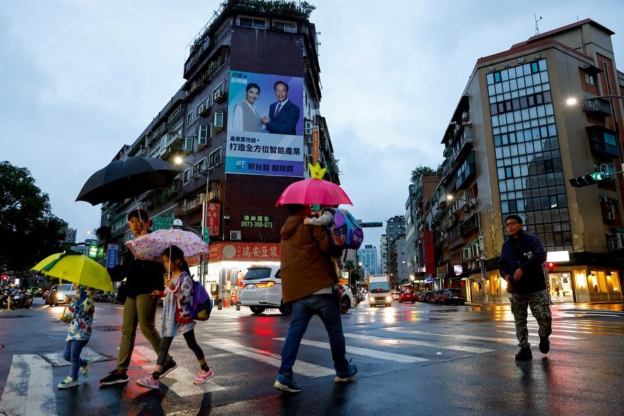 People cross a road in Taipei, Taiwan, on 14 November 2023. (Ann Wang/Reuters)