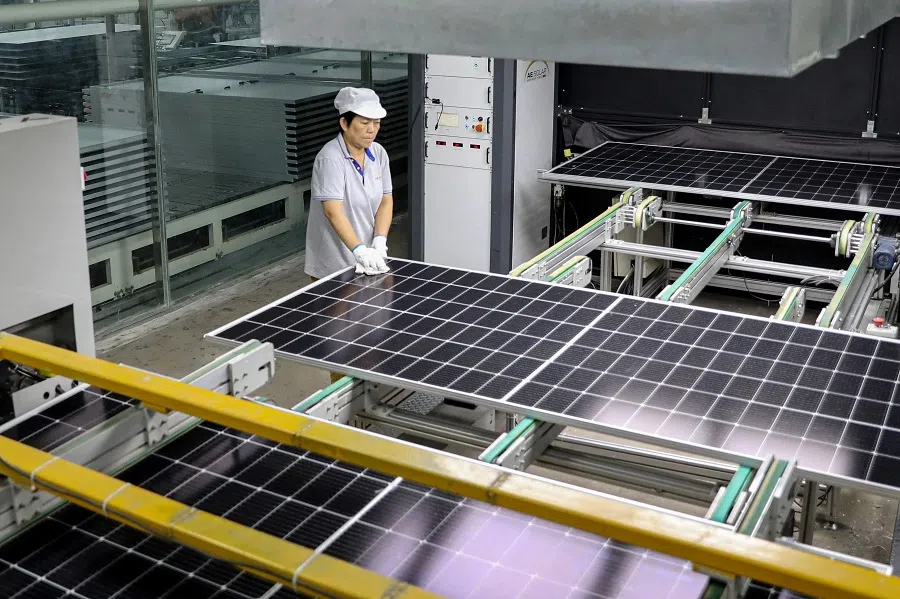 This photo taken on 5 September 2023 shows a worker producing solar photovoltaic modules used for solar panels at a workshop in Huaian, Jiangsu province, China. (AFP)