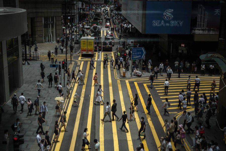 Pedestrians cross Queen's Road in the Central district in Hong Kong, 2 July 2020. (Ivan Abreu/Bloomberg)