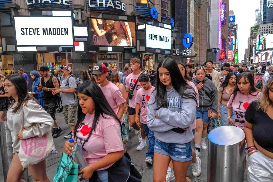 People walk through Times Square on 11 June 2024 in New York City, US. (Adam Gray/Getty Images/AFP)