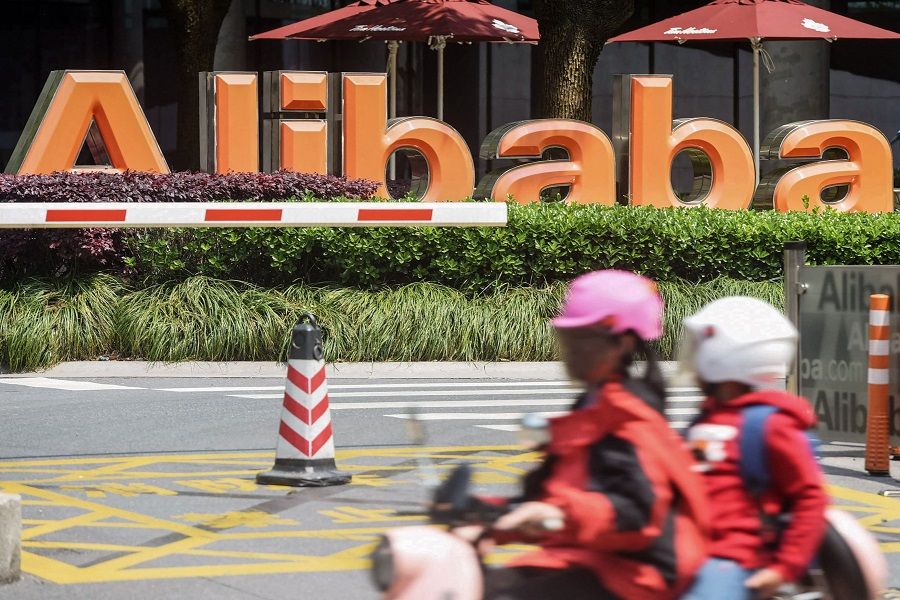 People commute past Chinese e-commerce giant Alibaba's headquarters in Hangzhou, Zhejiang province, China, on 26 May 2022. (AFP)