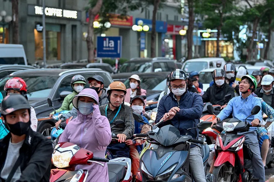 People sit on scooters as they wait in heavy traffic in Hanoi on 6 November 2024. (Nhac Nguyen/AFP)