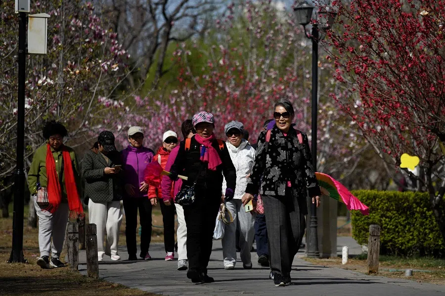 People visit a park in Beijing on 2 April 2025. (Wang Zhao/AFP)