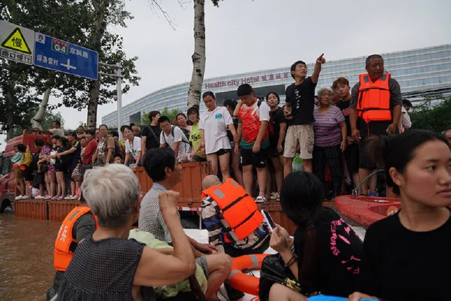 People standing on top of a truck waiting for relocation in Zhuozhou on 2 August 2023.