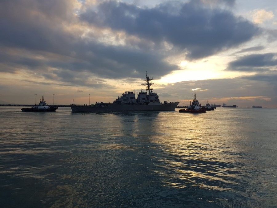 The Arleigh Burke-class guided missile destroyer USS John S. McCain (DDG 56) is towed away from the pier at Changi Naval Base, 5 October 2017. (Mass Communication Specialist 1st Class Micah Blechner)