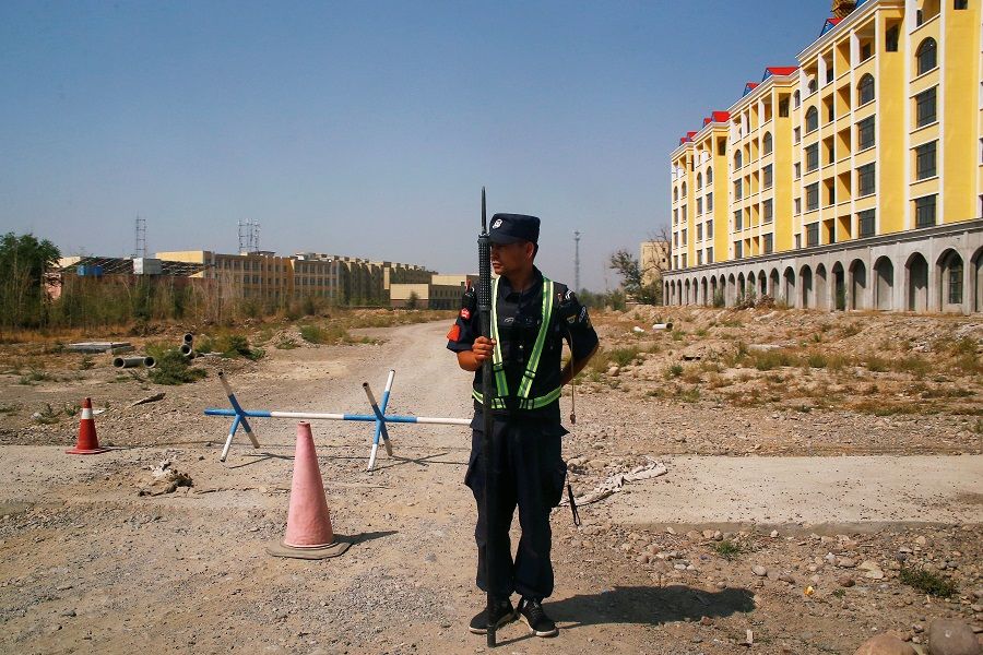 A Chinese police officer takes his position by the road near what is officially called a vocational education center in Yining in Xinjiang Uyghur Autonomous Region, China, 4 September 2018. (Thomas Peter/File Photo/Reuters)