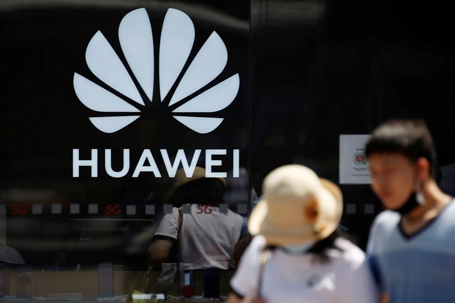 People walk past a Huawei logo on the facade of its store at a shopping complex in Beijing, China, 14 July 2020. (Tingshu Wang/File Photo/Reuters)